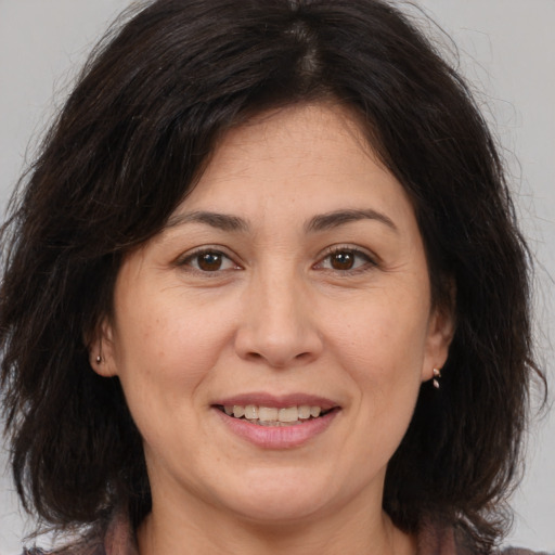 Joyful white adult female with medium  brown hair and brown eyes