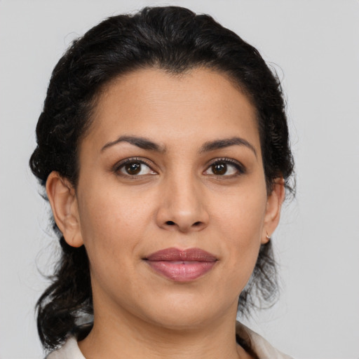 Joyful latino adult female with medium  brown hair and brown eyes