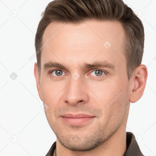 Joyful white young-adult male with short  brown hair and grey eyes