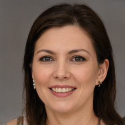 Joyful white adult female with long  brown hair and brown eyes