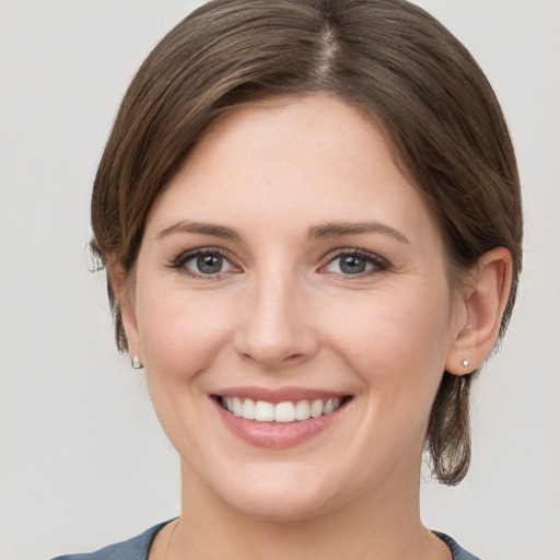 Joyful white young-adult female with medium  brown hair and grey eyes