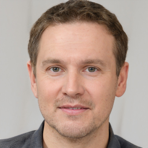 Joyful white adult male with short  brown hair and grey eyes