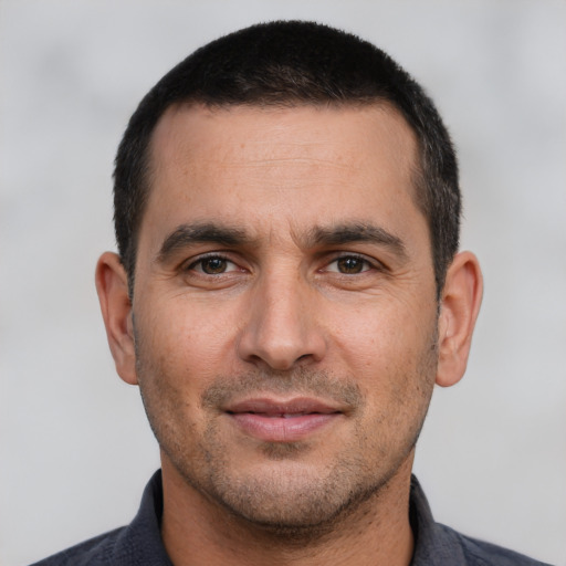 Joyful white young-adult male with short  black hair and brown eyes