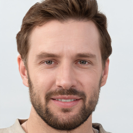 Joyful white young-adult male with short  brown hair and grey eyes