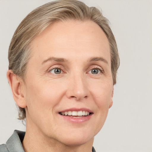 Joyful white adult female with medium  brown hair and grey eyes