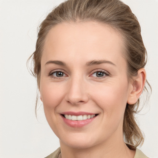 Joyful white young-adult female with medium  brown hair and grey eyes