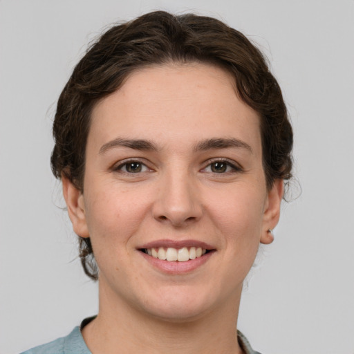 Joyful white young-adult female with short  brown hair and grey eyes