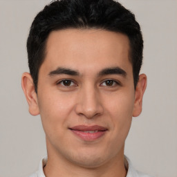 Joyful latino young-adult male with short  brown hair and brown eyes