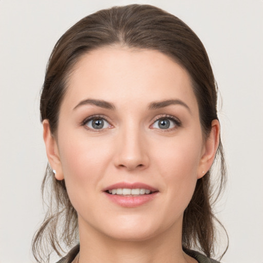 Joyful white young-adult female with medium  brown hair and grey eyes