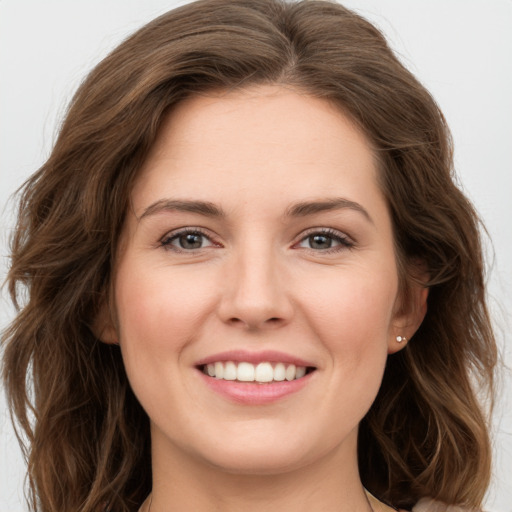 Joyful white young-adult female with long  brown hair and green eyes