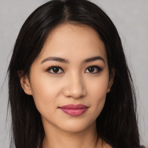 Joyful latino young-adult female with long  brown hair and brown eyes