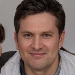 Joyful white adult male with short  brown hair and brown eyes