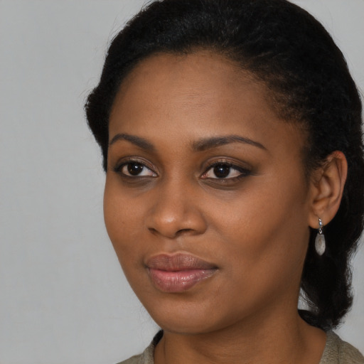 Joyful black young-adult female with long  black hair and brown eyes