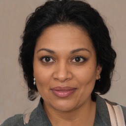 Joyful black adult female with medium  brown hair and brown eyes