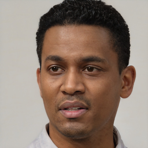 Joyful black young-adult male with short  black hair and brown eyes