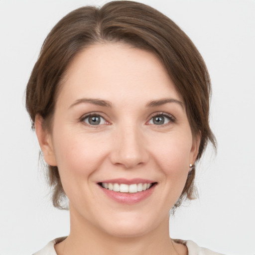 Joyful white young-adult female with medium  brown hair and grey eyes