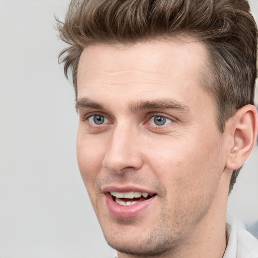 Joyful white young-adult male with short  brown hair and grey eyes