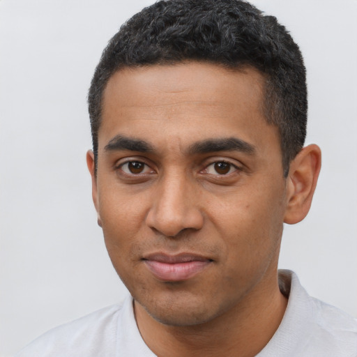 Joyful black young-adult male with short  black hair and brown eyes