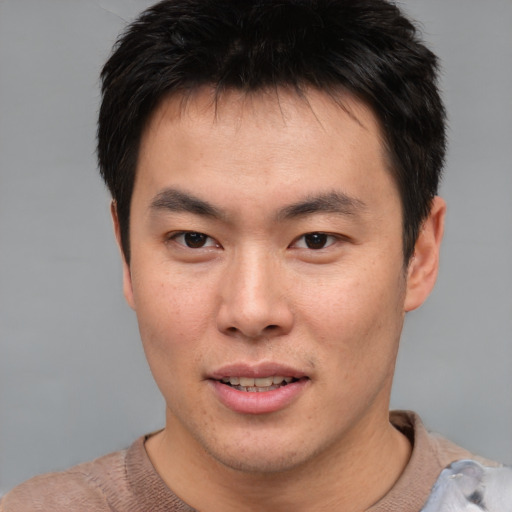 Joyful asian young-adult male with short  brown hair and brown eyes