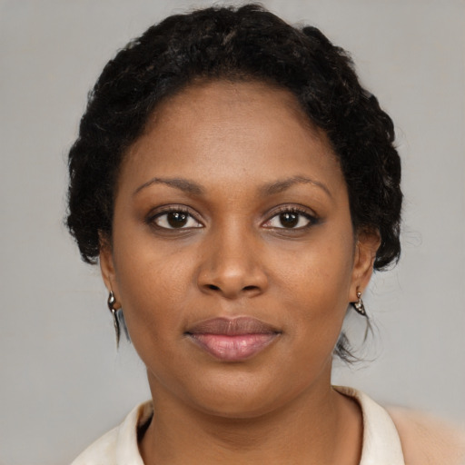 Joyful black young-adult female with short  brown hair and brown eyes
