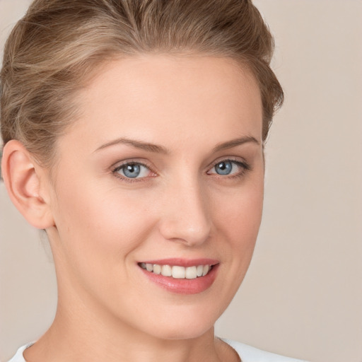 Joyful white young-adult female with short  brown hair and blue eyes