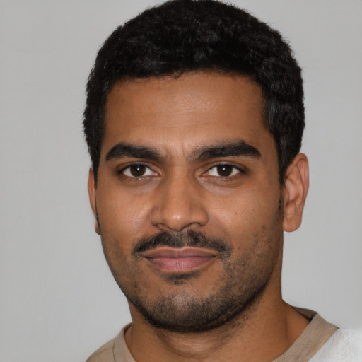 Joyful black young-adult male with short  black hair and brown eyes