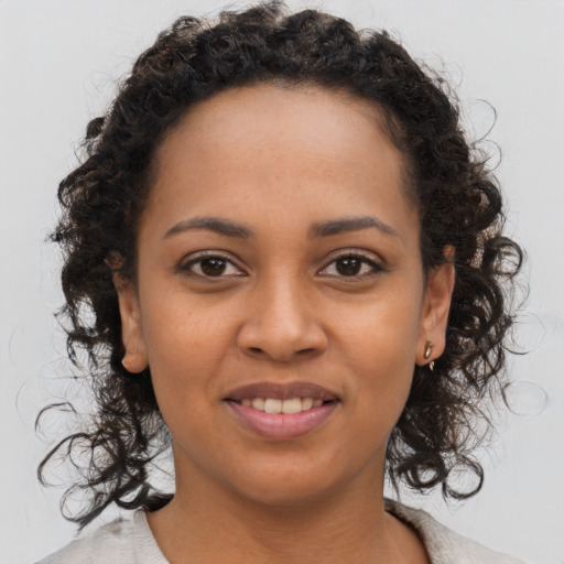 Joyful black young-adult female with medium  brown hair and brown eyes