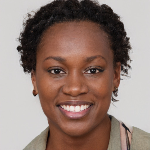 Joyful black young-adult female with short  brown hair and brown eyes