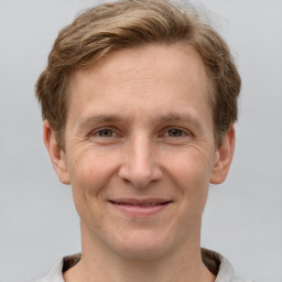 Joyful white adult male with short  brown hair and grey eyes