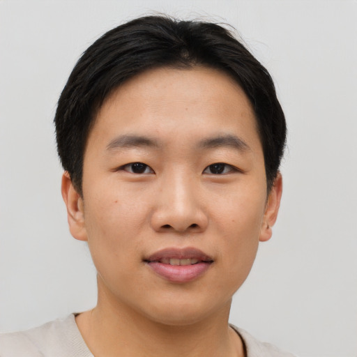 Joyful asian young-adult male with short  brown hair and brown eyes