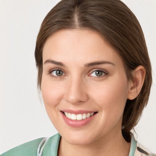 Joyful white young-adult female with medium  brown hair and grey eyes