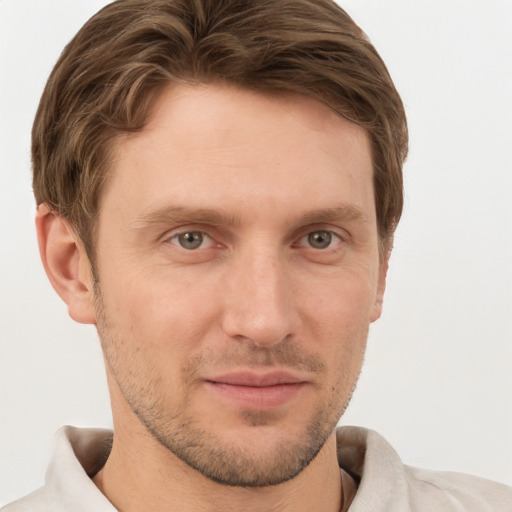 Joyful white young-adult male with short  brown hair and grey eyes