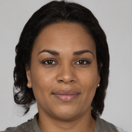 Joyful black young-adult female with medium  brown hair and brown eyes