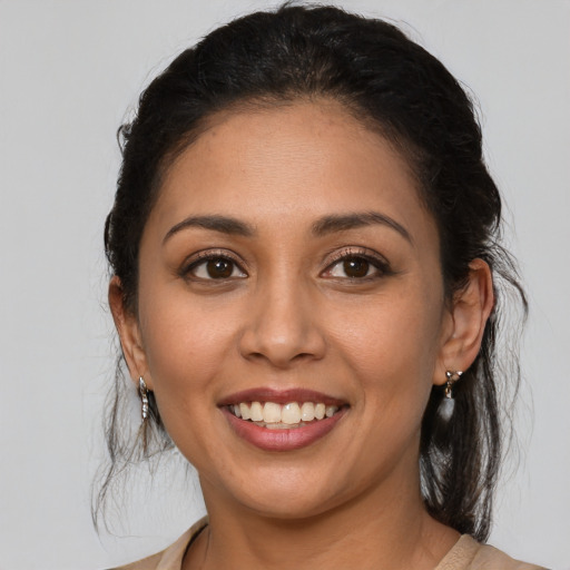 Joyful latino young-adult female with medium  brown hair and brown eyes