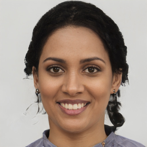 Joyful black young-adult female with medium  black hair and brown eyes