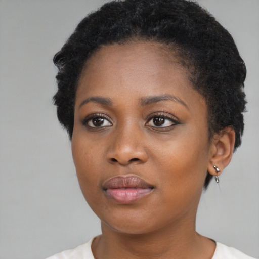 Joyful black young-adult female with short  black hair and brown eyes