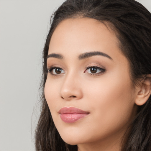 Joyful latino young-adult female with long  brown hair and brown eyes