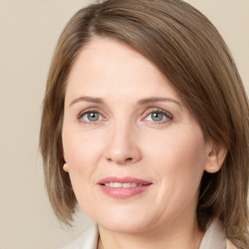 Joyful white young-adult female with medium  brown hair and green eyes