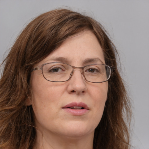 Joyful white adult female with long  brown hair and blue eyes