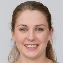 Joyful white young-adult female with medium  brown hair and grey eyes