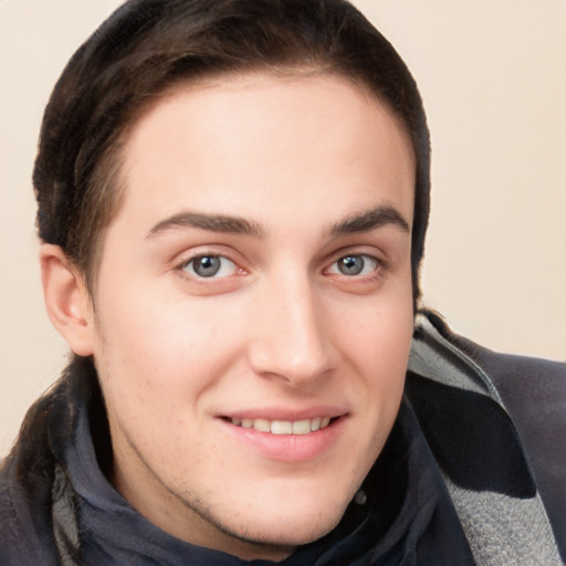 Joyful white young-adult male with long  brown hair and grey eyes