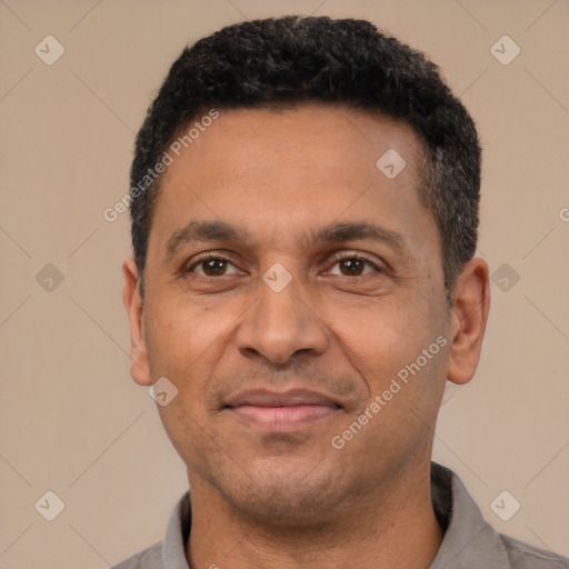 Joyful latino adult male with short  black hair and brown eyes