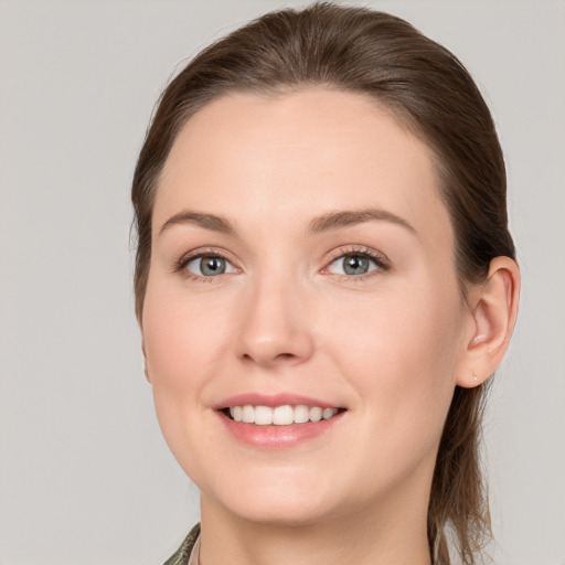 Joyful white young-adult female with long  brown hair and grey eyes