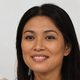 Joyful latino young-adult female with long  brown hair and brown eyes