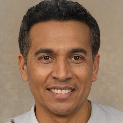 Joyful latino adult male with short  black hair and brown eyes