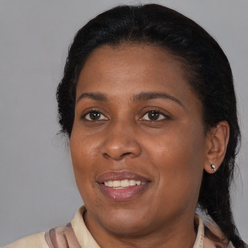 Joyful black adult female with medium  brown hair and brown eyes