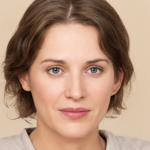 Joyful white young-adult female with medium  brown hair and green eyes