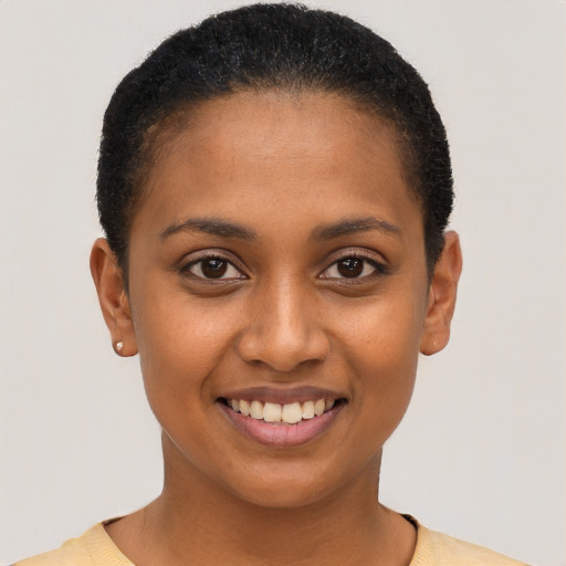 Joyful black young-adult female with short  black hair and brown eyes