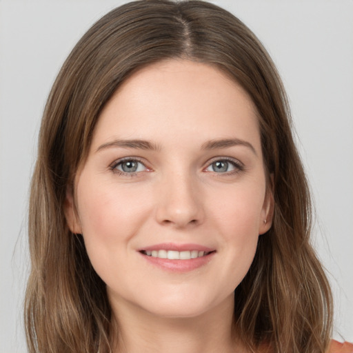 Joyful white young-adult female with long  brown hair and grey eyes