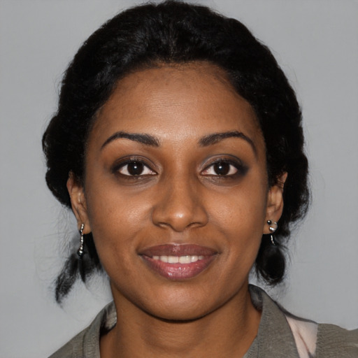 Joyful black young-adult female with medium  black hair and brown eyes